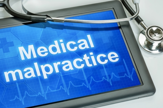 Tablet screen displaying “Medical malpractice” with stethoscope, symbolizing the connection between healthcare education and malpractice accountability