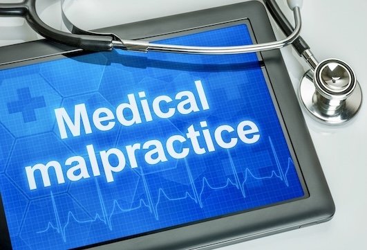 Tablet screen displaying “Medical malpractice” with stethoscope, symbolizing the connection between healthcare education and malpractice accountability